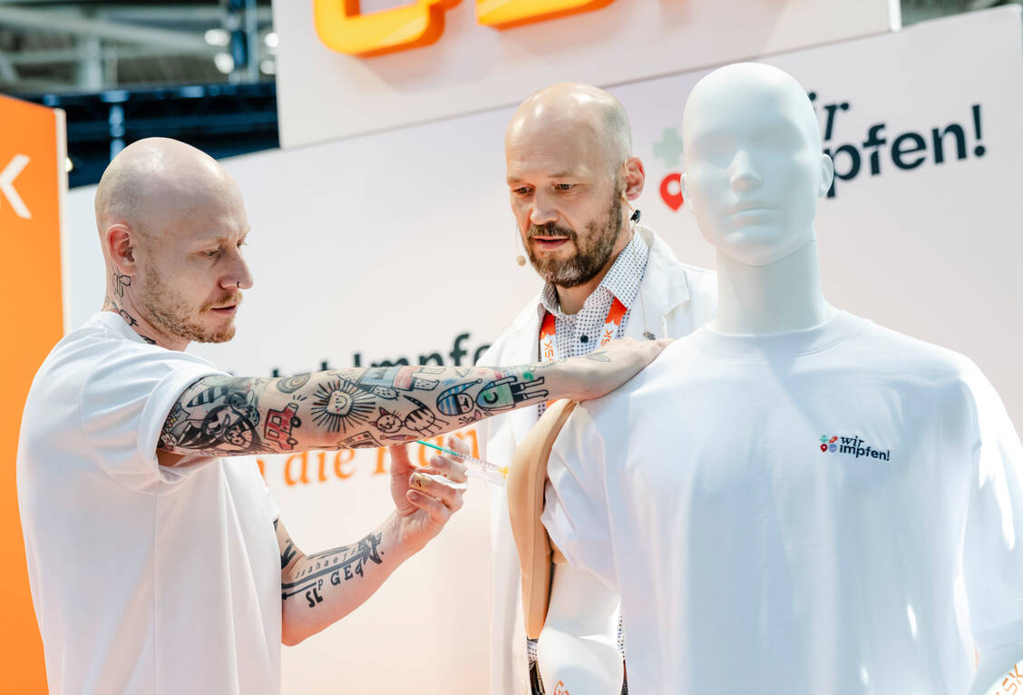 Das praktische Impfen wird unter ärztlicher Aufsicht geübt – meist erst einmal an einem Dummy, dann partnerschaftlich mit Kochsalzlösung. Auf der Expopharm konnte man es schon einmal ausprobieren. / © Avoxa/Expopharm