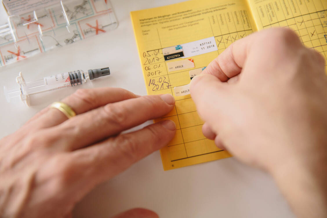 Die Dokumentation von Impfungen machen viele Apotheken fast komplett digital – nur das Einkleben des Chargenaufklebers erfolgt vorerst noch analog. / © Getty Images/Westend61