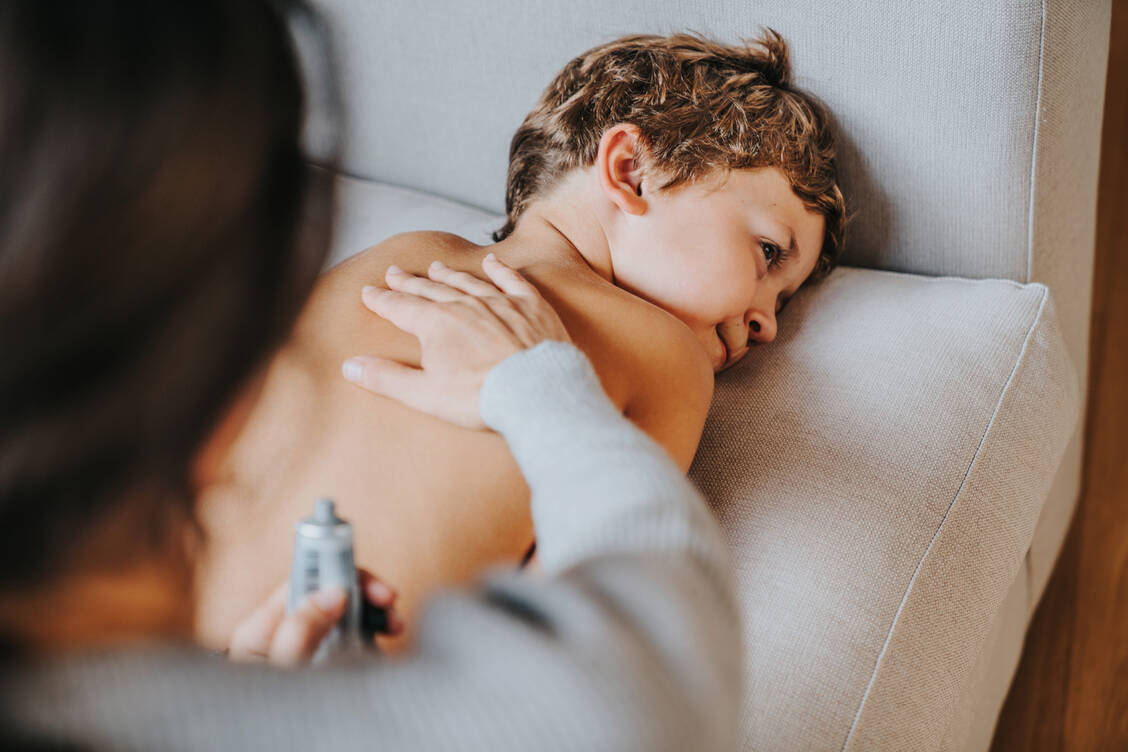 Erkältungssalben, die auf Brust und Rücken aufgetragen werden, enthalten ätherische Öle. Bei Kindern unter zwei Jahren sind Menthol und Campher tabu. / © Getty Images/Orbon Alija