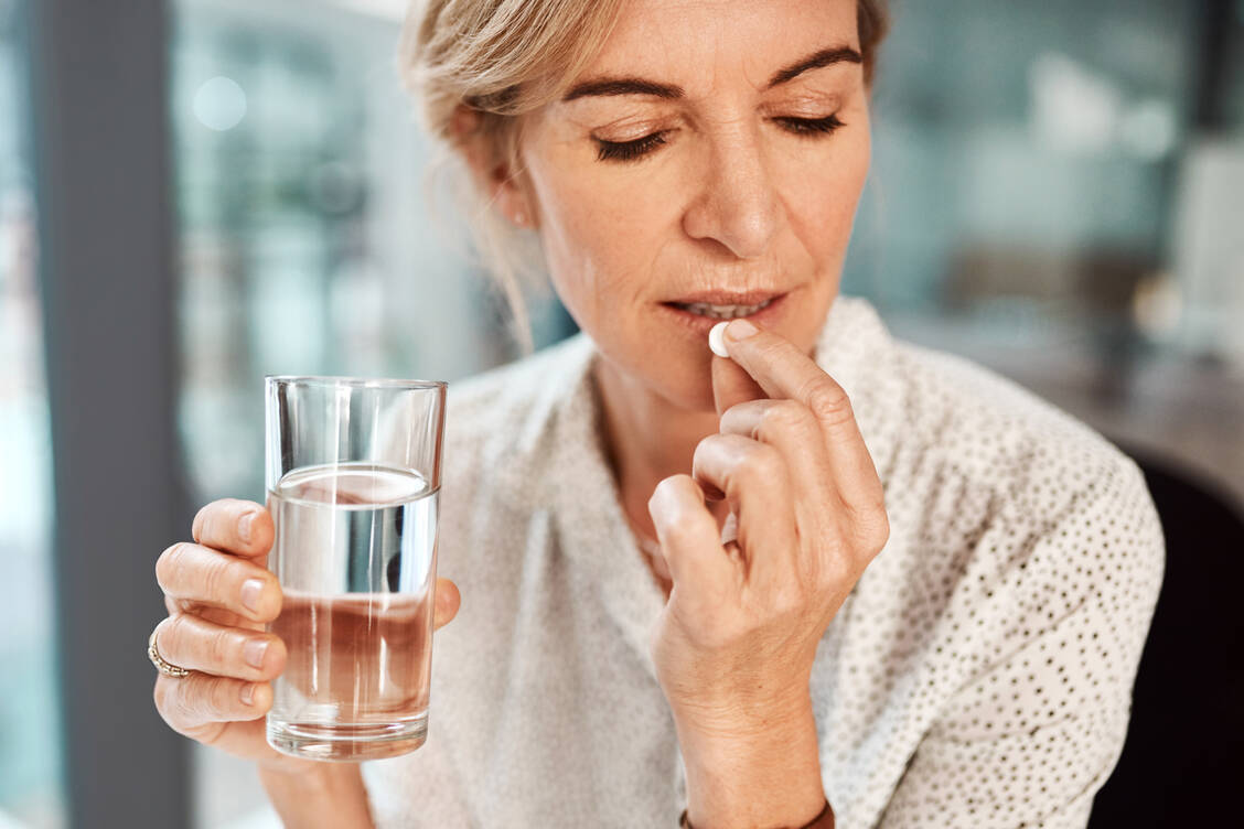 In aufrechter Position mit einem großen Glas Wasser: So sollten Tabletten geschluckt werden, um ein Festhaften in der Speiseröhre zu vermeiden. / © Getty Images/People Images