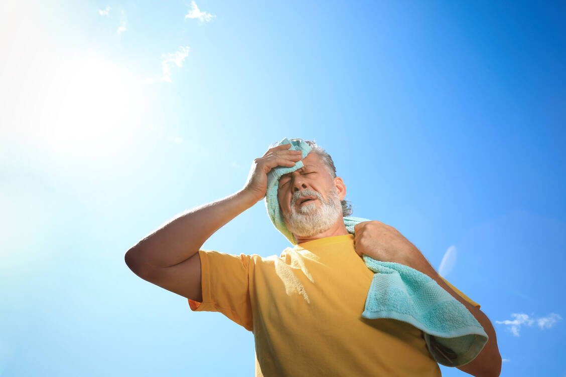 Ob jung oder alt: Vor allem mittags sollte sich im Sommer niemand in der prallen Sonne aufhalten. Zudem schützt ein Sonnenhut oder eine Cap vor einem Sonnenstich. / Foto: Adobe Stock/New Africa/Olga Yastremska