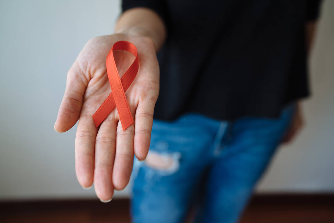 Die rote Schleife steht für Solidarität mit HIV-Infizierten und einen offenen Umgang mit der Erkrankung. Der ist wichtig, um Infektionen frühzeitig zu entdecken und zu behandeln. / Foto: Getty Images/Burak Karademir