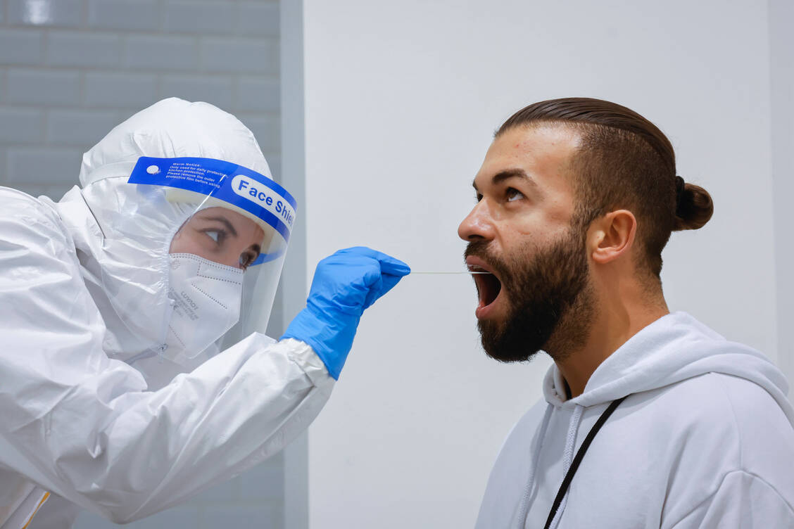 Diese Schutzvorkehrungen wie hier auf dem Foto werden sowohl bei der Durchführung von PCR- als auch bei Schnelltests benötigt. / Foto: imago images/Rupert Oberhäuser