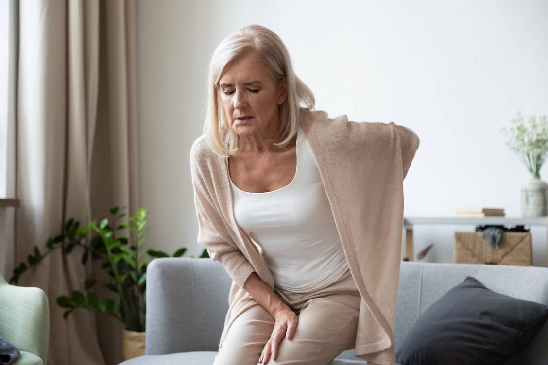 Starke Rückenschmerzen bei älteren Damen können Anzeichen eines Wirbelbruchs infolge von Osteoporose sein. / Foto: Adobe Stock/fizkes