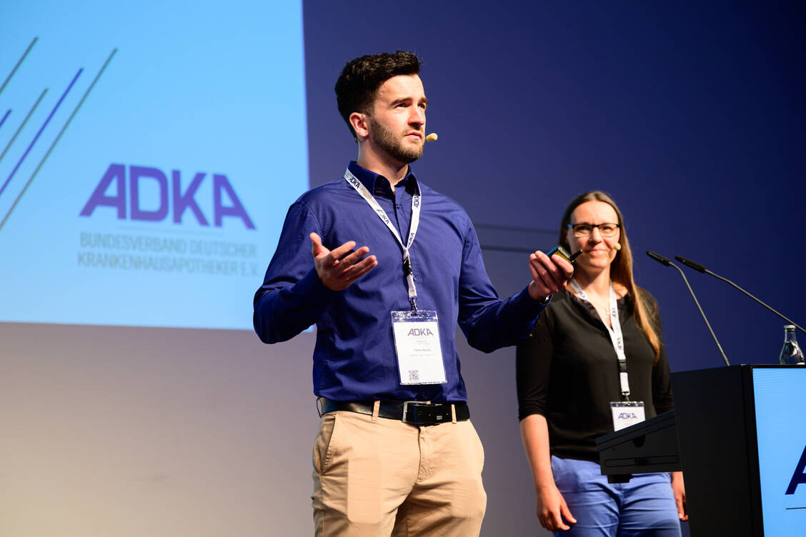Stellten stellvertretend für die Gruppe aus zehn beteiligten Krankenhausapothekerinnen und -apothekern den neuen ADKA-Standard auch anhand eines Patientenbeispiels vor: Patryk Mysior (Kliniken der Stadt Köln) und Caroline Maria Griesel (Uniklinikum der RWTH Aachen). / © Avoxa/Matthias Merz