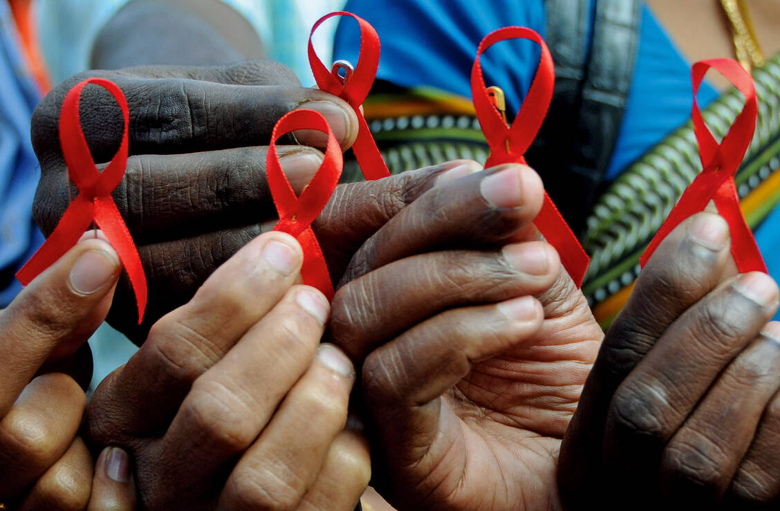 Die rote Schleife steht seit den frühen Neunzigern für die Solidarität mit HIV-Infizierten und Aids-Kranken. / Foto: dpa
