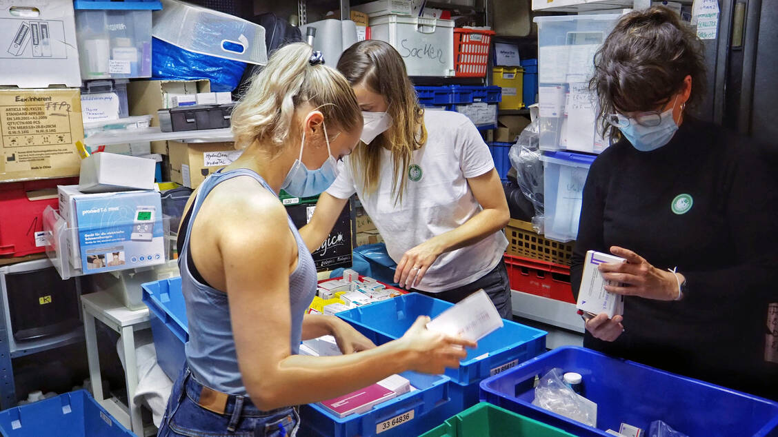 Freiwillige Helfer von AoG sortieren alte Medikamente in der Obdachlosen-Ambulanz Berlin aus. / Foto: Apotheker ohne Grenzen