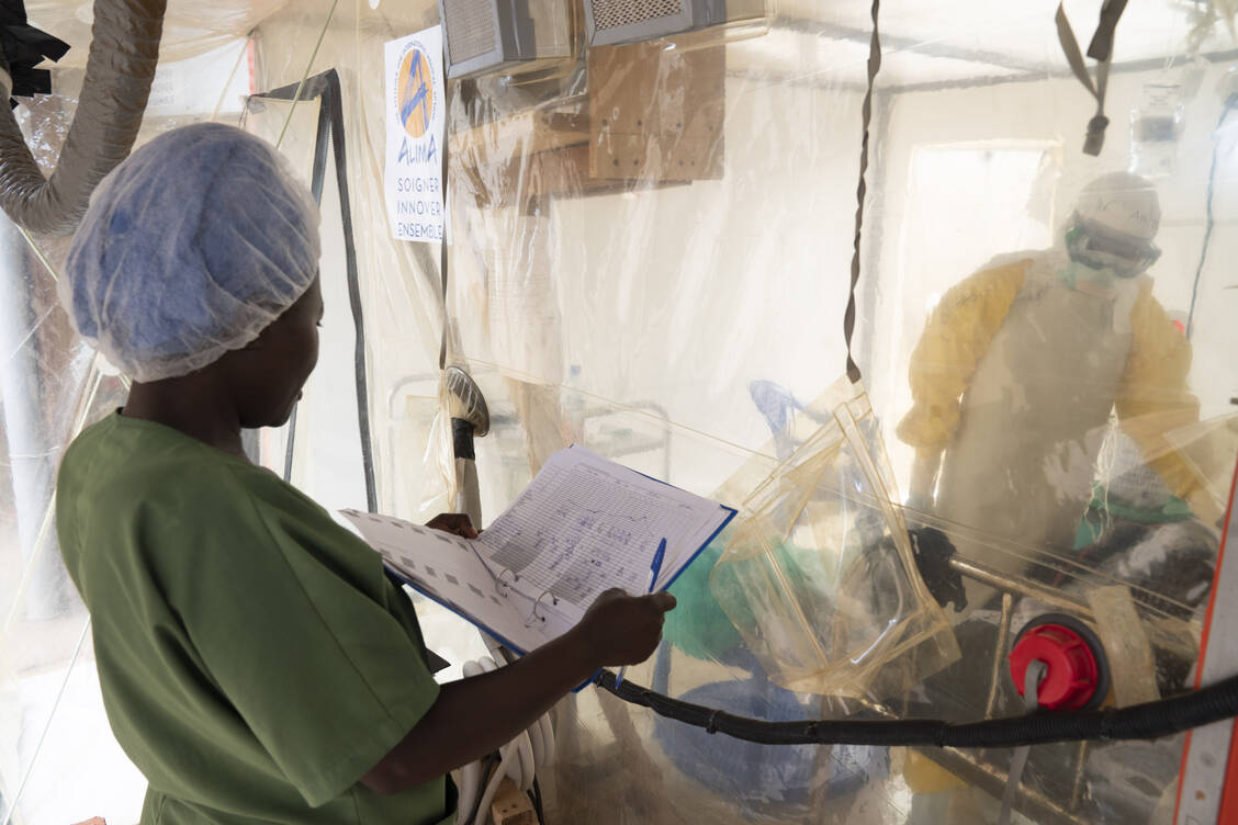 Im ALIMA Ebola Treatment Centre, Beni, kontrolliert eine Krankenschwester die Werte eines Patienten, der in einem transportierbaren Schutzzelt behandelt wird. / Foto: WHO/Christopher Black
