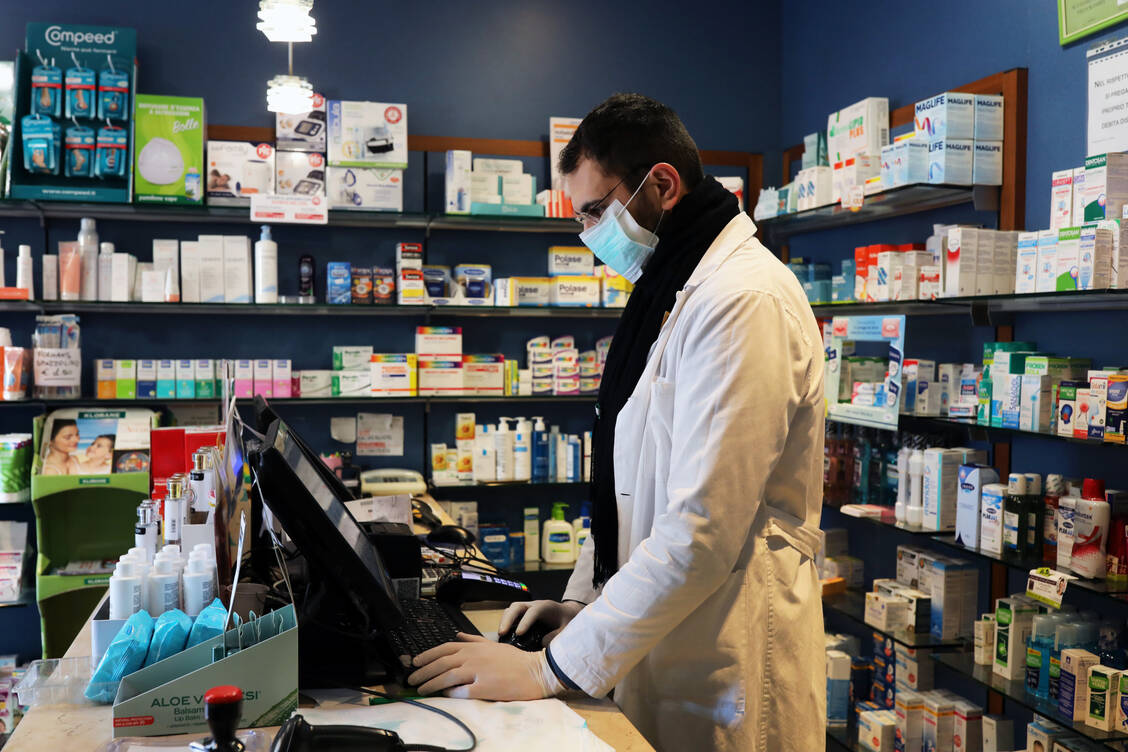Bei einer Pandemie sieht der Handverkauf anders aus als sonst. In italienischen Apotheken arbeiten die Mitarbeiter mit Handschuhen und Mundschutz. / Foto: Getty Images/Marco Di Lauro