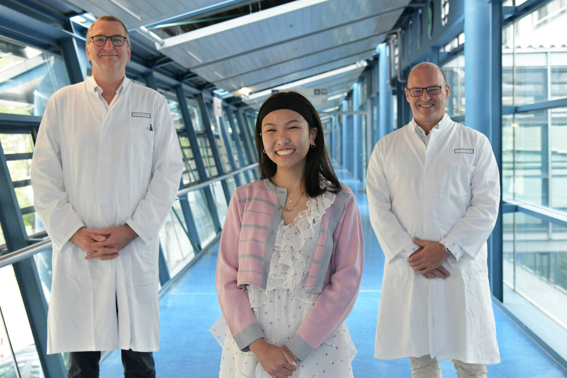 Professor Dr. Andreas Mackensen (links) und Professor Dr. Georg Schett freuen sich mit ihrer Patientin Thu-Thao V. darüber, dass die Therapie mit CAR-T-Zellen so gut bei ihr angeschlagen hat. / Foto: Alessa Sailer/Uni-Klinikum Erlangen