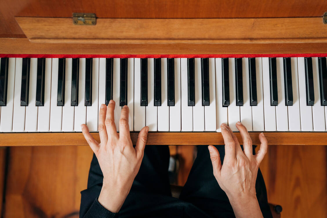 Bei Menschen, die Klavierspielen lernen, kommt es zu einer automatischen Kopplung der neuronalen Netzwerke, die für die Sensomotorik und das Hören zuständig sind. / Foto: Getty Images/Portra
