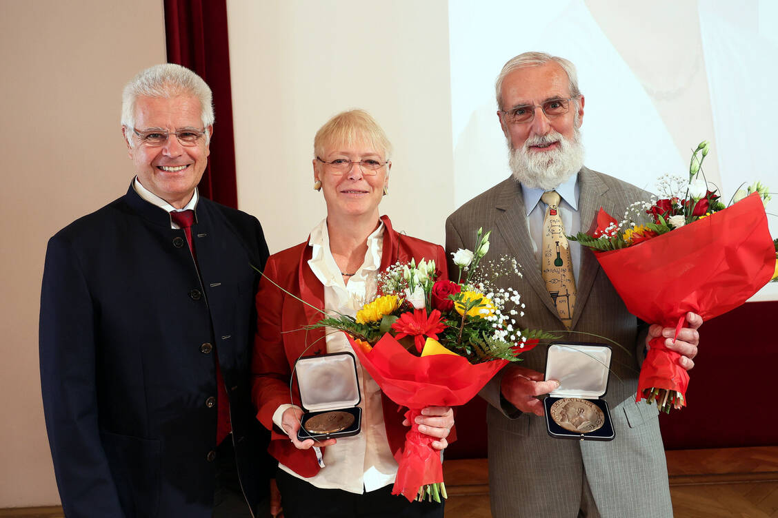BAK-Präsident Thomas Benkert (links) verlieh in Meran die Lesmüller-Medaille als Zeichen besonderer Verdienste an Apothekerin Annette van Gessel und Apotheker Dr. Wolfgang Strölin. / Foto: PZ/Alois Müller
