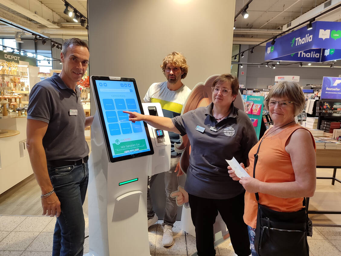 Gilbert-Peter Boullay (links), Michael Kranz und Dörte Haferung erklären einer Kundin das Terminal.  / Foto: Edeka Nord
