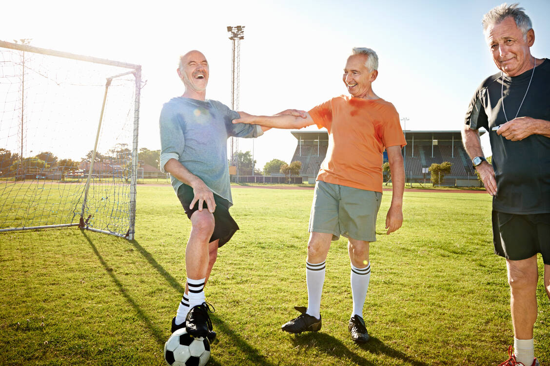Ball flach halten: Walking Football bringt Bewegung ins Altern. / © Getty Images/Uwe Krejci
