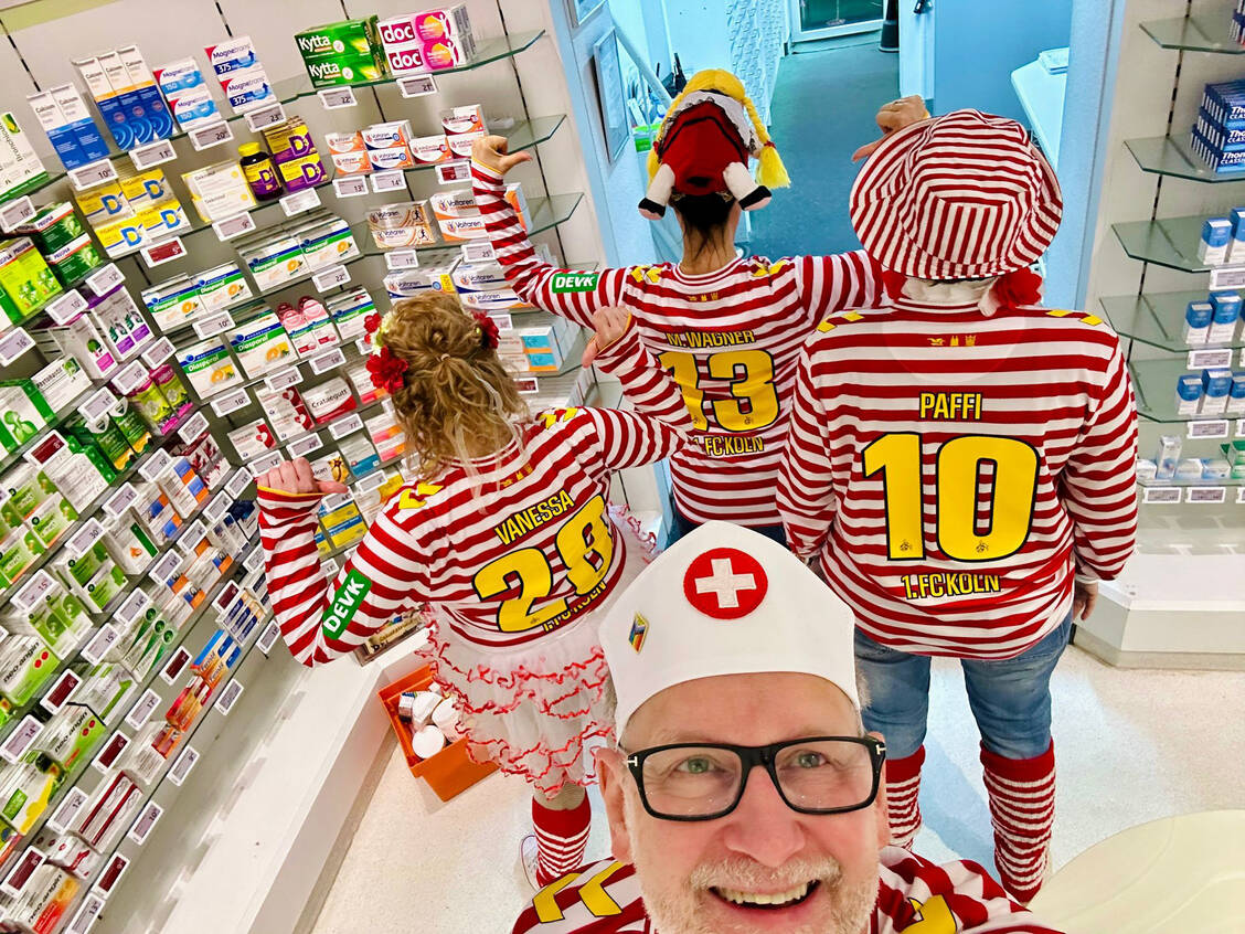 Auch das vierköpfige Team der Offizin der Paradies-Apotheke in Köln ist heute verkleidet. Jeder trägt ein FC-Köln-Trikot mit seinem Namen. / © Paradies Apotheke