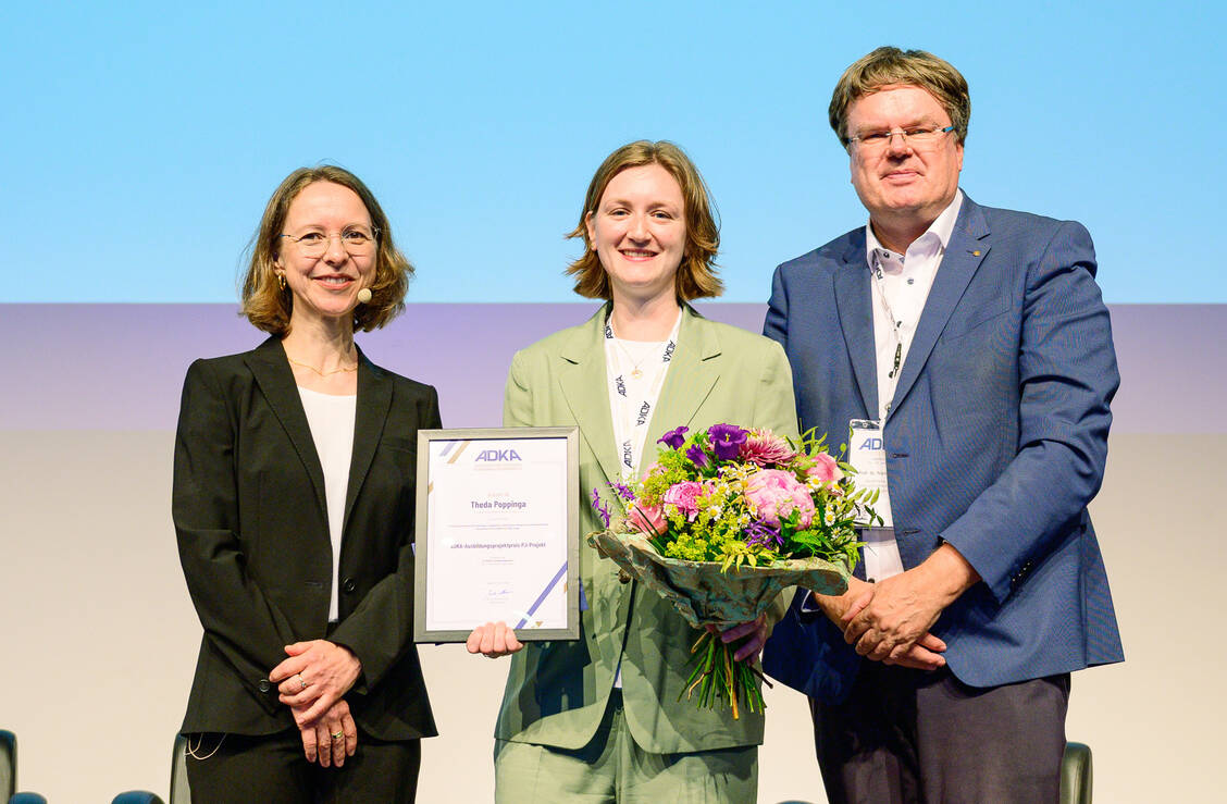 Professor Dr. Stefanie Swoboda (links) und Professor Dr. Frank Dörje überreichten Theda Poppinga (Mitte) eine Urkunde und Blumen. / © Avoxa/Matthias Merz