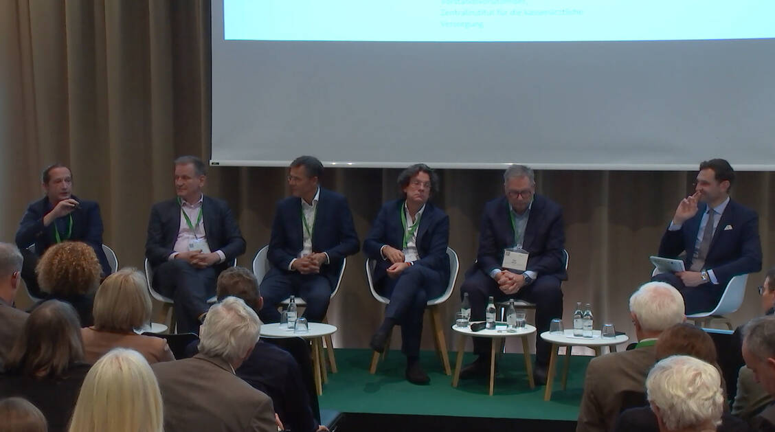 (v. l. n. r.) Thomas Czihal (Zentralinstitut für Kassenärztliche Versorgung), Bernhard van Treeck (Gemeinsamer Bundesausschuss), Matthias Meergans (vfa), Frank Sieren (Wirtschaftsjournalist), Karl Broich (BfArM) und Moderator Andreas Beivers. / © Screenshot: 25. Europäischer Gesundheitskongress, München 2026