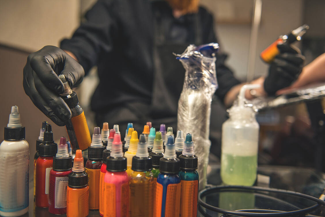 Als Gemische aus Pigmenten, Trägerflüssigkeit, Verdickern, Konservierungsmitteln und einer Vielzahl anderer teilweise unbekannter Einzelsubstanzen bergen Tattoo-Farben besondere Risiken. / Foto: Adobe Stock/Yakobchuk Olena