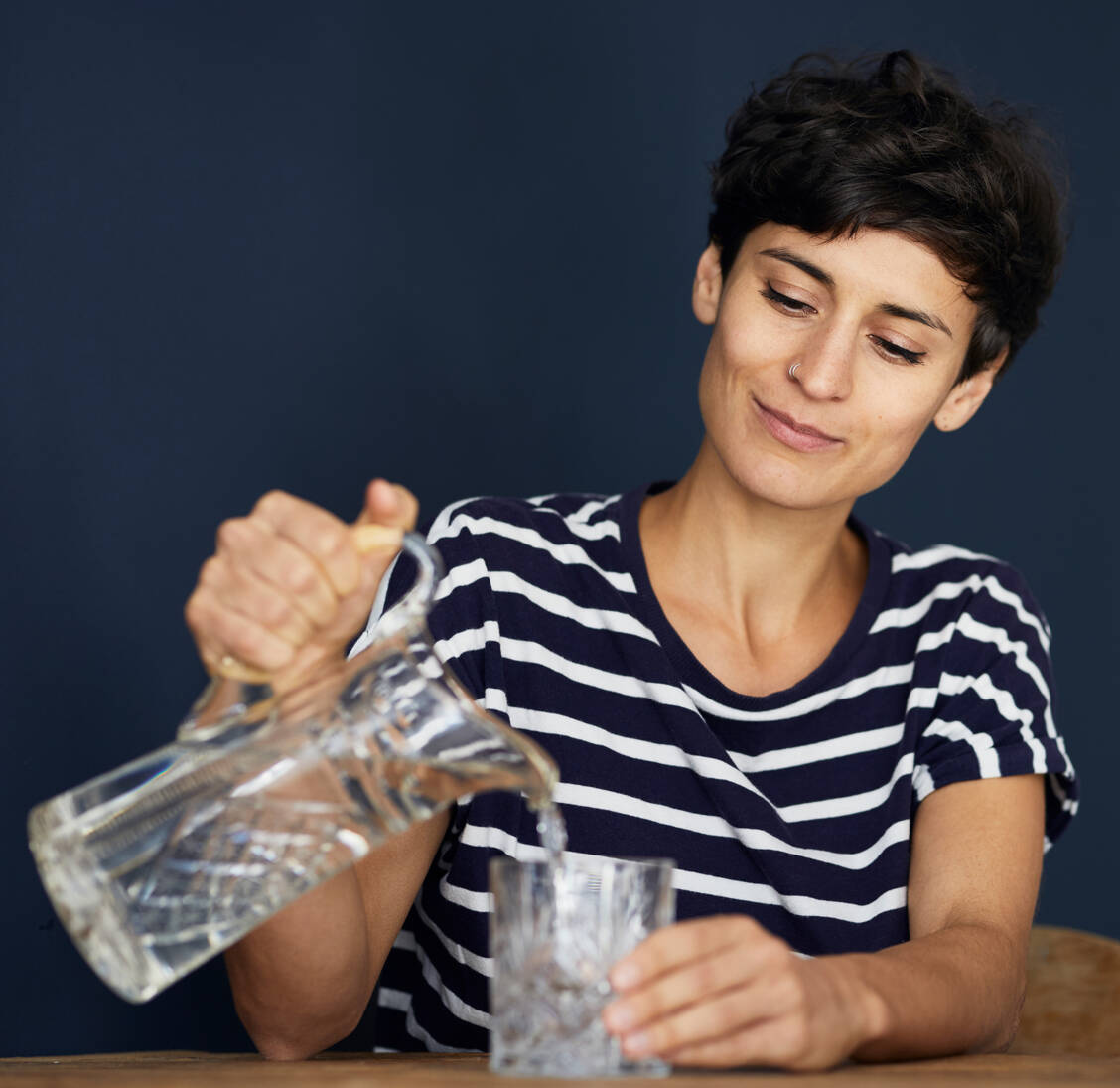 Um zu verhindern, dass der Apfelessig den Zahnschmelz angreift, sollte man nach der Einnahme ein Glas Wasser trinken und eine halbe Stunde warten, bevor man sich die Zähne putzt. / Foto: Getty Images/Westend61