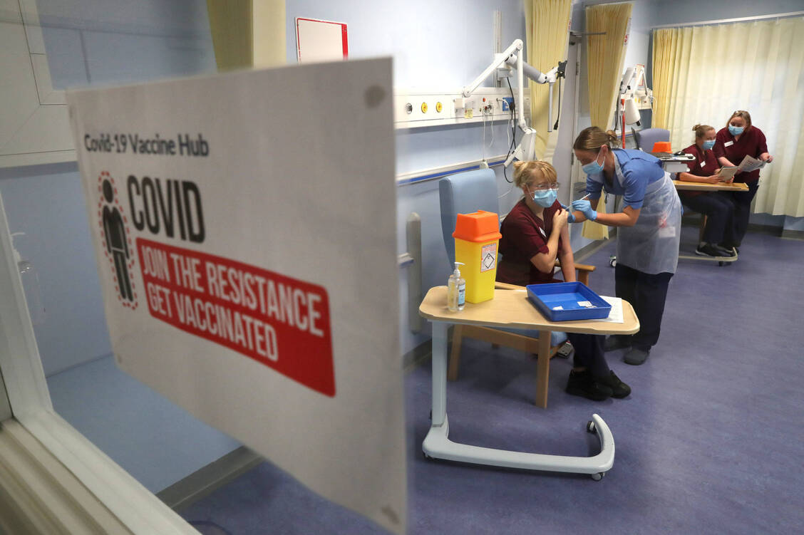 Impfstart am 8. Dezember 2020 in Edinburgh: Krankenschwester Katie McIntosh verabreicht die erste von zwei Dosen des Covid-19-Impfstoffs Comirnaty an eine Kollegin. Die größte Impfkampagne aller Zeiten in Großbritannien scheint langsam Früchte zu tragen. / Foto: imago images/i Images
