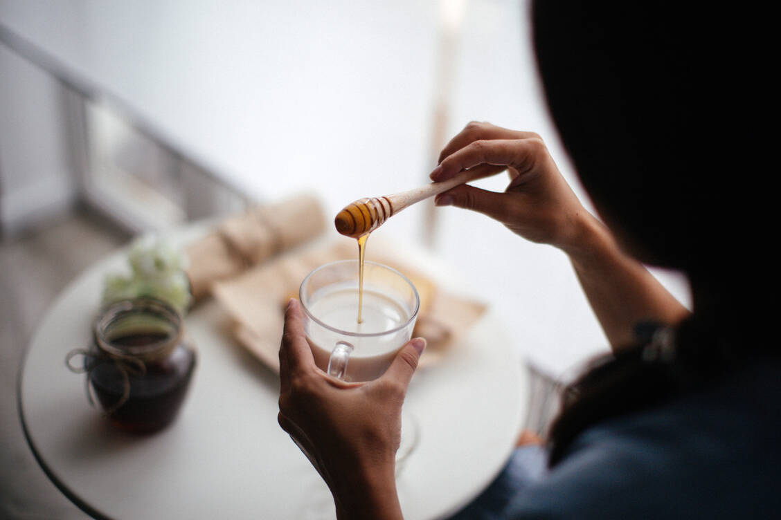 Geschmackssache: Ob heiße Milch mit Honig bei Erkältungen hilft, ist wissenschaftlich nicht belegt. Mit einem wohligen Placeboeffekt ist jedoch zu rechnen und schaden tut sie nicht. Beim Einrühren sollte die Milch übrigens nicht zu heiß sein. / © Getty Images/Blueline studio/StefaNikolic