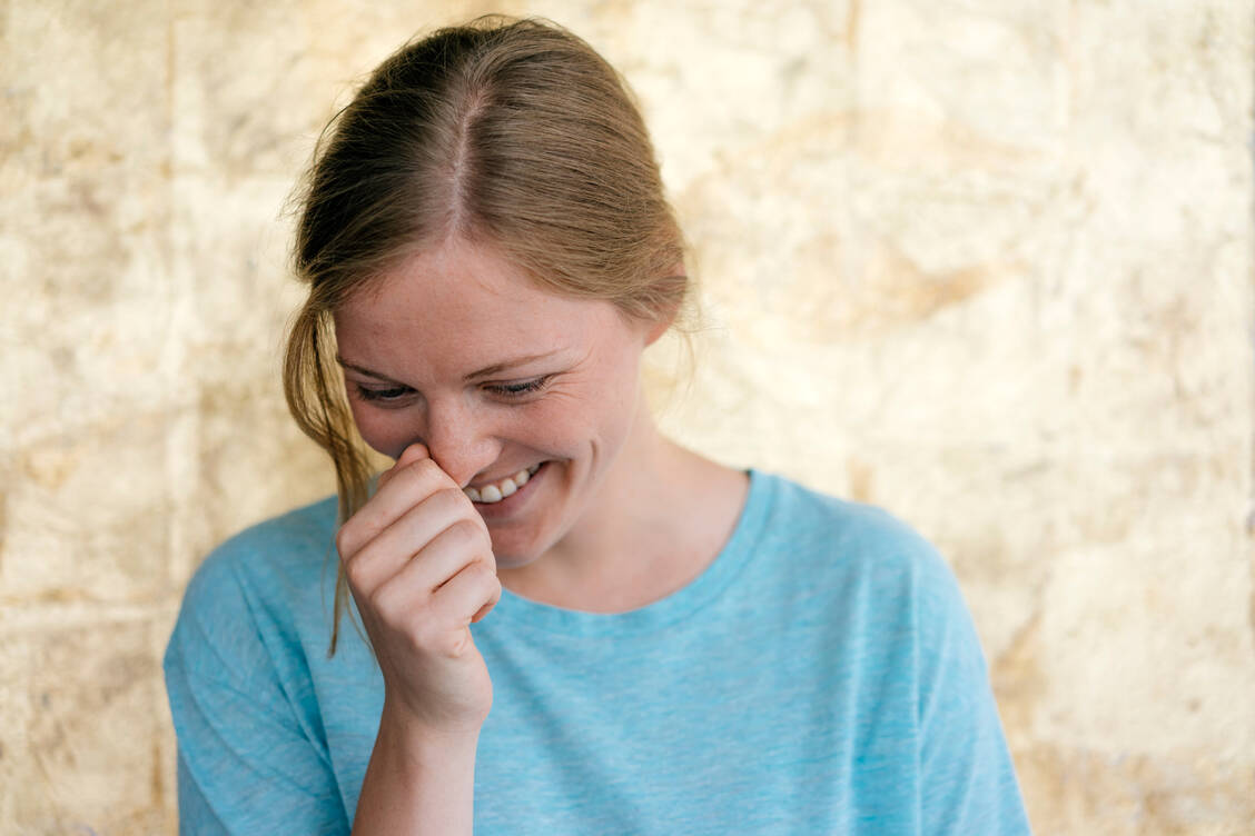 Lachen zu unterdrücken, kann sehr schwierig sein. Doch es gibt Strategien, die mehr oder minder erfolgreich sind. / © Getty ImagesWestend61