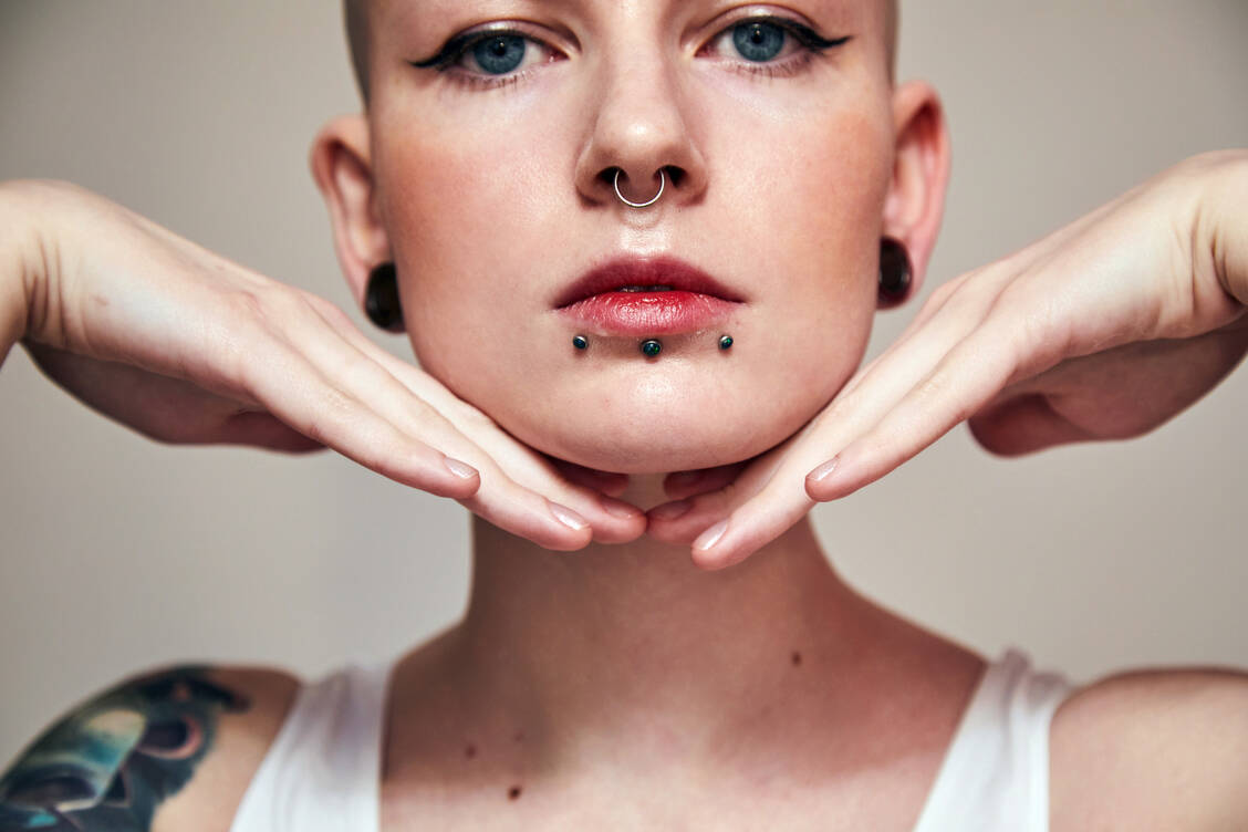 Tattoo, Piercing, Ohrtunnel: Menschen haben viele Gründe, warum sie ihren Körper intensiv verändern lassen. Viele haben Freude an einem ausgefallenen Körperschmuck. / Foto: Adobe Stock/Yakobchuk Olena