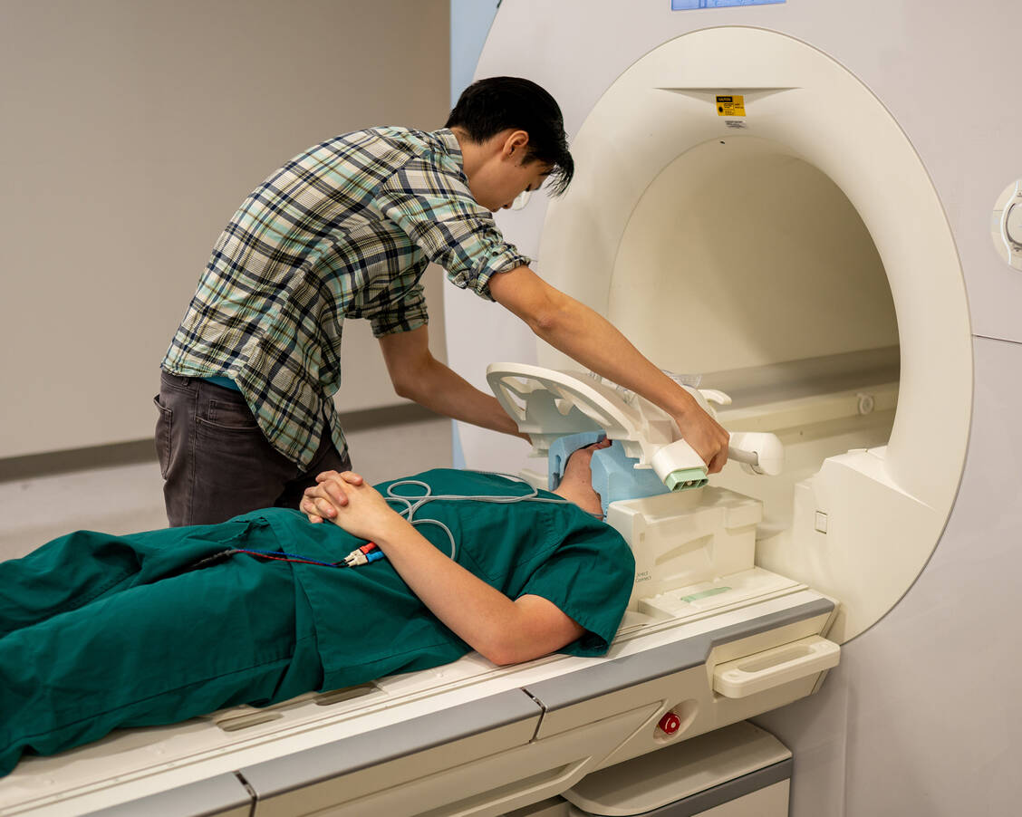 »Gedanken lesen« ist (noch?) technisch aufwändig und ungenau. Hier bereitet Doktorand Jerry Tang einen Probanden für den Hirnscan im fMRT vor. / Foto: University of Texas at Austin/Nolan Zunk