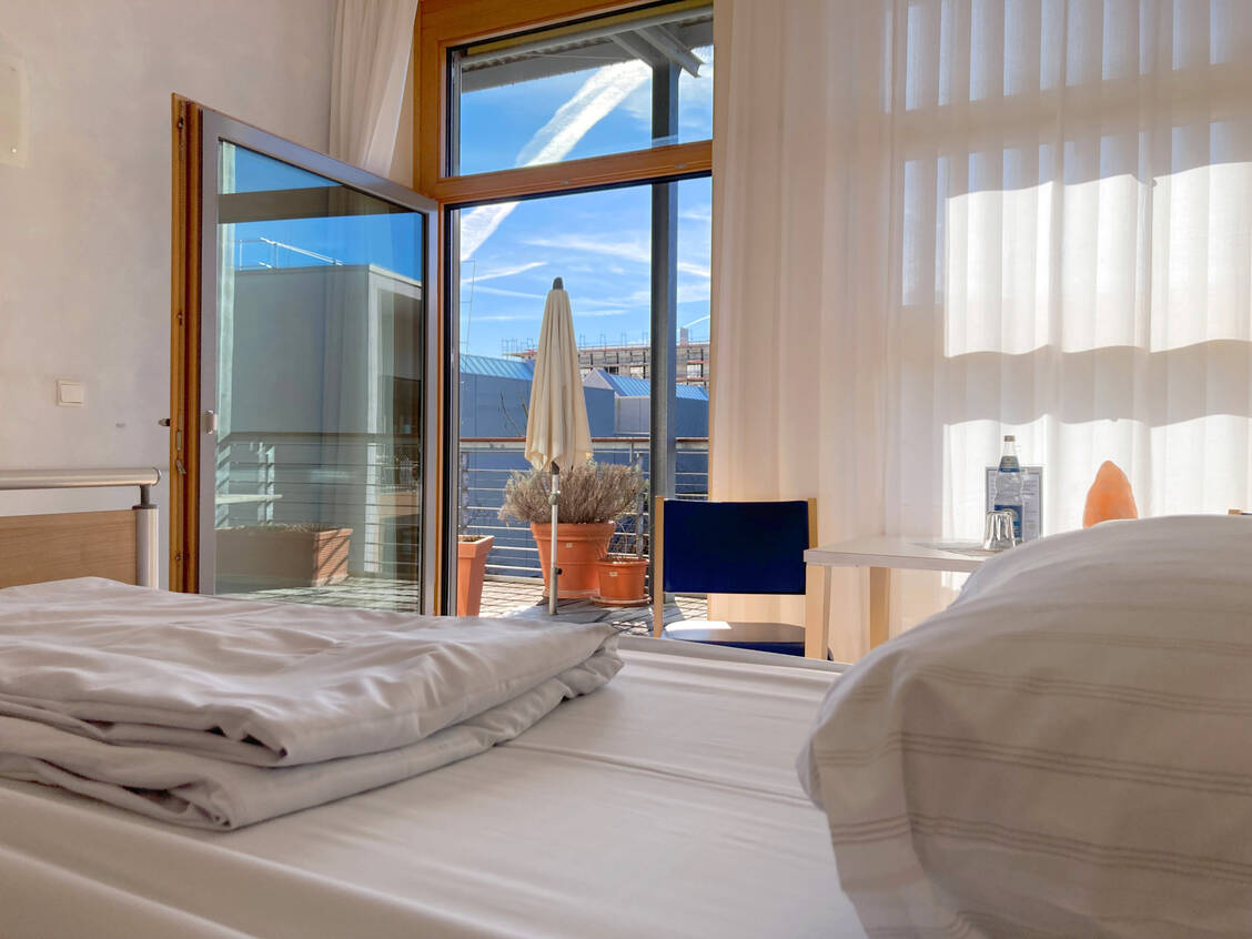 Jedes der zehn Einzelzimmer hat Zugang zum Balkon. Bei gutem Wetter kann auch das gesamte Bett samt Patient nach draußen geschoben werden. / © PZ/Laura Rudolph