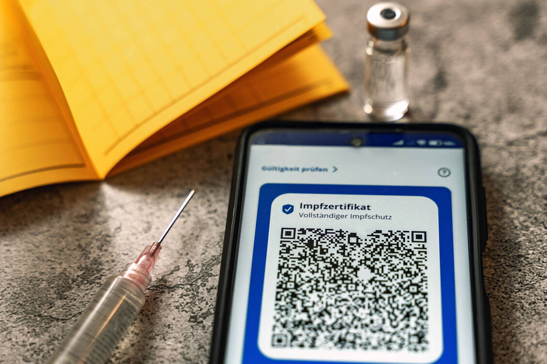 Zur Erlangung von digitalen Impfzertifikaten müssen analoge Impfdokumente in der Apotheke vorgelegt werden. Ob die Vorlage von gefälschten Impfpässen auch strafbar ist, ist derzeit juristisch umstritten. / Foto: Imago Images/Bihlmayerfotografie