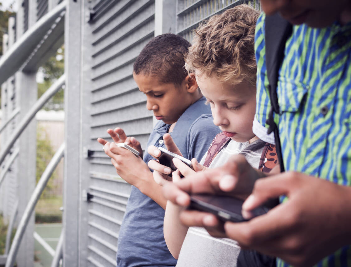 Swipen statt wippen auf dem Spielplatz: Längst ein alltägliches Bild. Spätestens mit Beginn der weiterführenden Schule fordern Kinder ein eigenes Smartphone, ein vernünftiger Umgang damit muss aber gelernt werden. / Foto: Adobe Stock/bramgino
