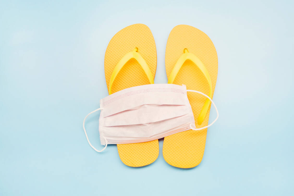 Masken gehören auch im Sommer 2022 weiterhin ins Reisegepäck und in jede Handtasche. / Foto: Getty Images/the_burtons 2020