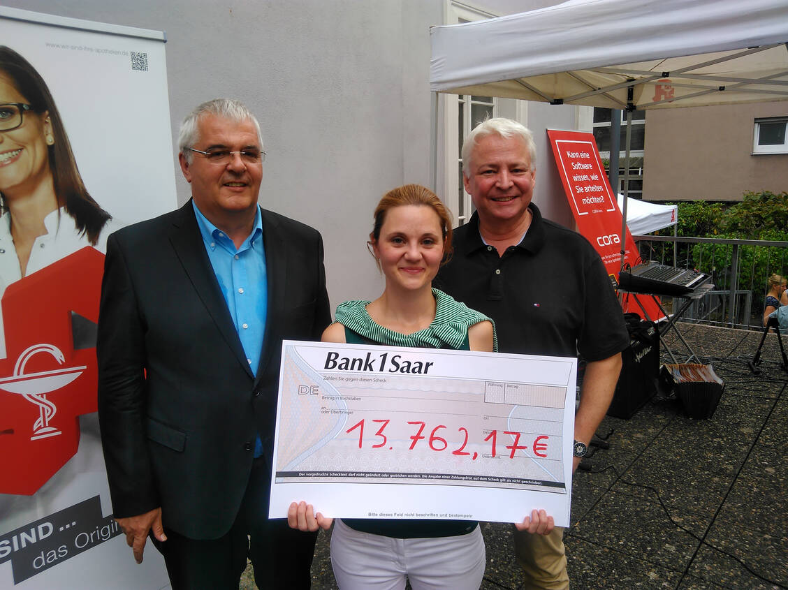 Manfred Saar (links), Präsident der Apothekerkammer des Saarlandes, und Susanne Koch, Vorsitzende des Saarländischen Apothekervereins, überreichen Thomas Rosch vom Saarländischen Rundfunk einen Scheck für die Kinderhilfsaktion »Herzenssache — hilft Kindern«. / Foto: AKdS