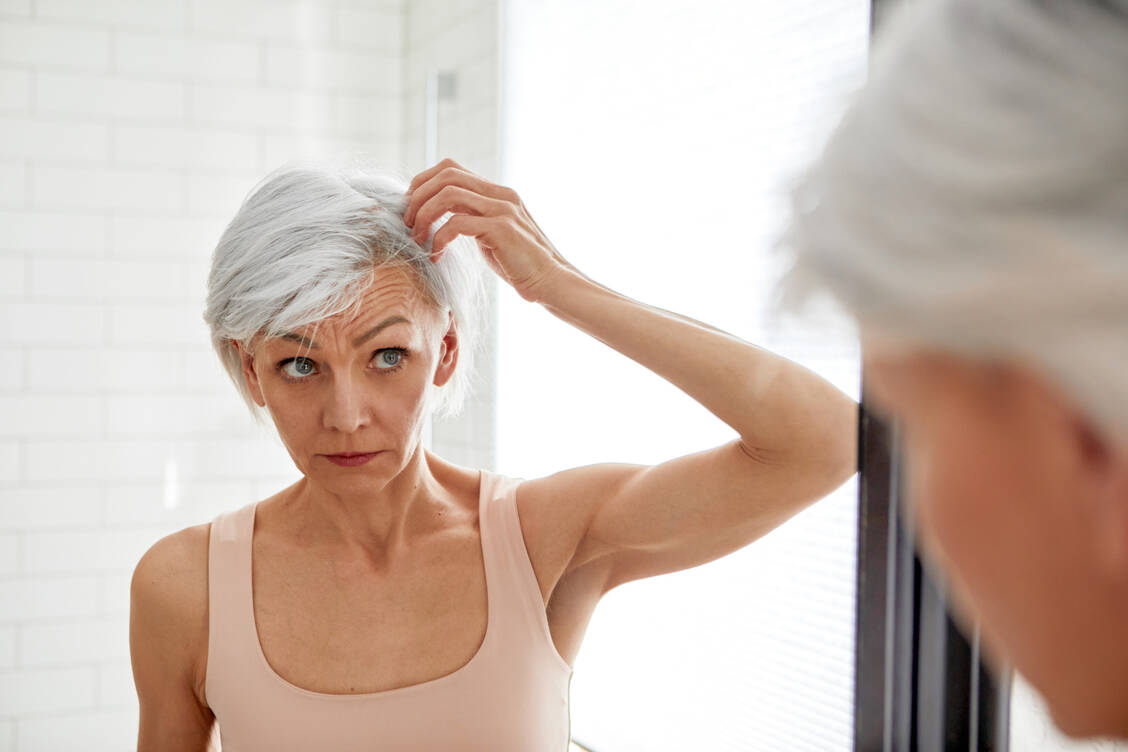 Auch bei Frauen kann mit zunehmendem Alter das Haar lichter werden. Da mit dem Klimakterium Estrogen fehlt, führt Dihydrotesteron wie bei Männern zu einem verstärkten Haarausfall. / Foto: Getty Images/Ekaterina Demidova