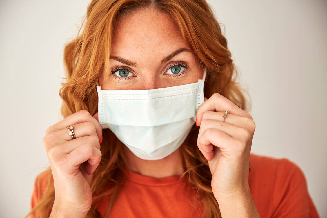 Die Maske selbst sollte aus hygienischen Gründen nicht berührt, sondern an den Bändern angefasst werden. Sie gehört weder unter das Kinn noch ans Handgelenk, sondern am besten in eine Plastiktüte, wenn sie nicht getragen wird. / Foto: Getty Images/Westend61