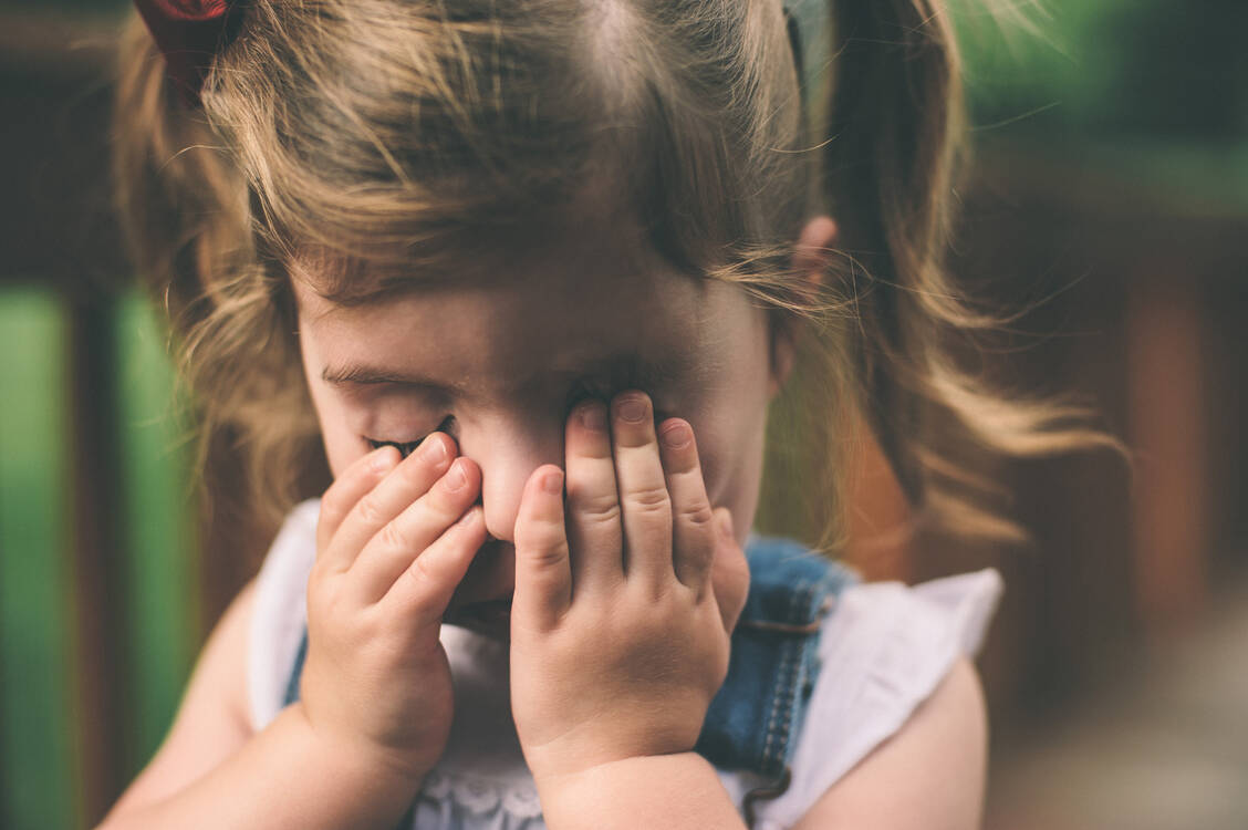 Drückt das Kind die Hände an den Kopf oder vor die Augen, kann das ein Hinweis darauf sein, dass es an Kopfschmerzen leidet. / Foto: Adobe Stock/Samantha’s Studio