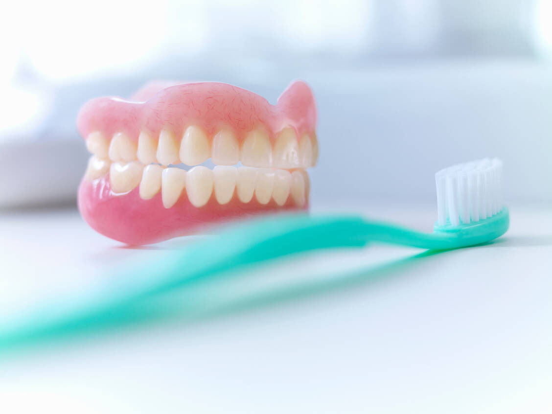 Zweimal am Tag putzen: Diese Regel gilt nicht nur für die eigenen Zähne, sondern auch für künstliche. / © Adobe Stock/Adam Gault/KOTO