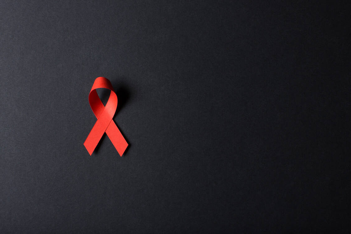 Die Rote Schleife steht weltweit für Solidarität mit HIV-positiven und aidskranken Menschen. / © Getty Images/Boris Zhitkov