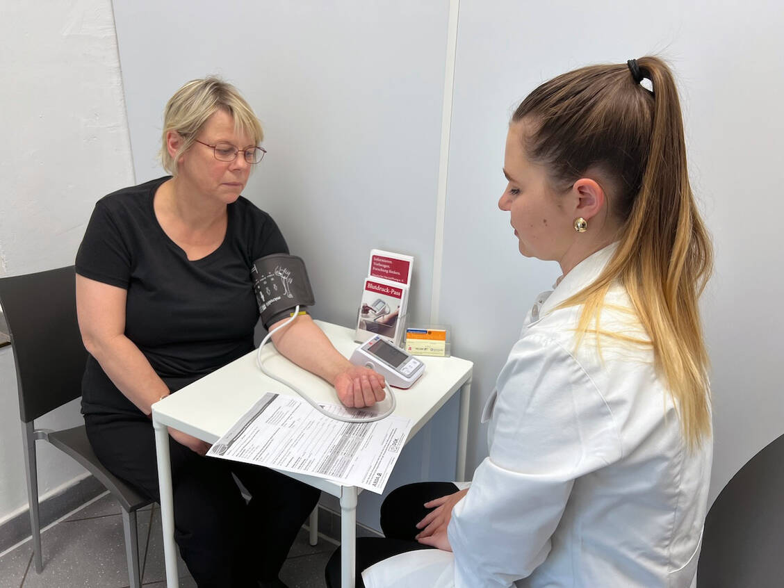 Pharmaziepraktikantin Julia Elisabeth Markus (rechts) beteiligte sich während der Herzwoche an der Aktion »Risikocheck hoher Blutdruck« und kontrollierte den Blutdruck von Patientinnen und Patienten in der Steintor-Apotheke in Halle.  / Foto: AKSA/Katrin Pohl