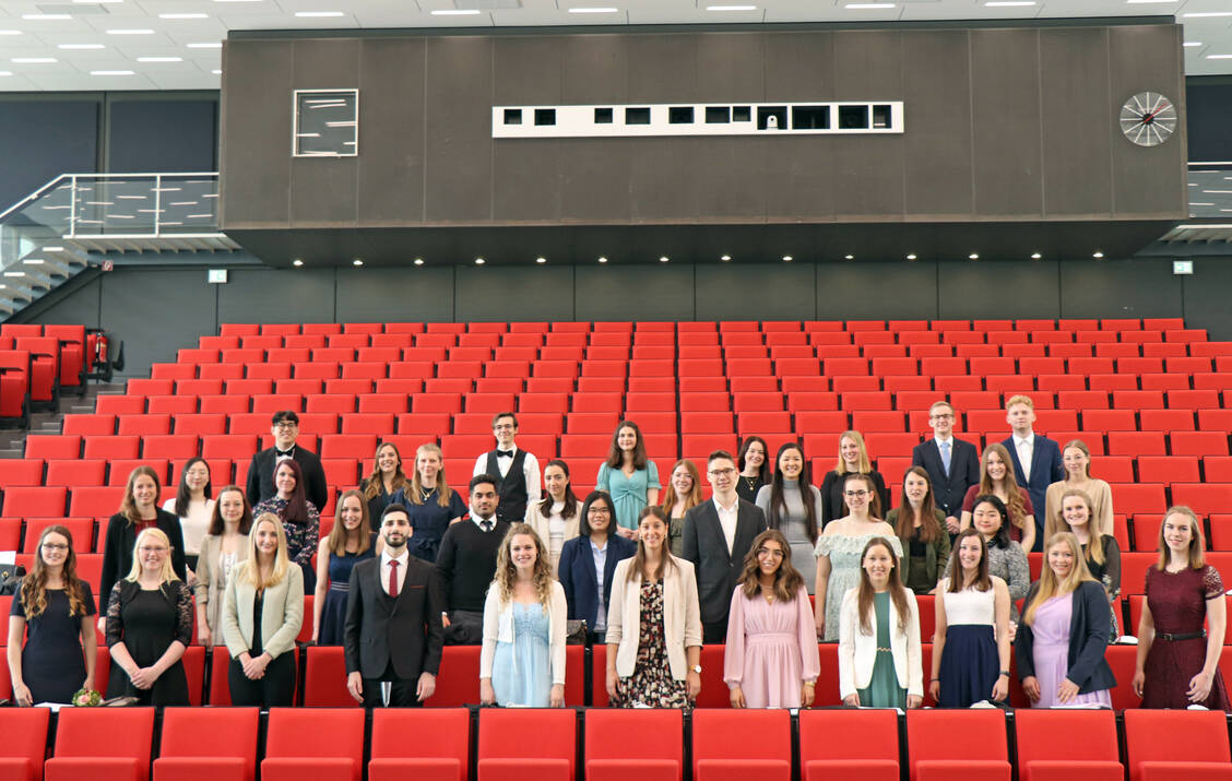 Die Absolventen und Absolventinnen des Wintersemesters 2021/22 stehen im Audimax der TU Braunschweig.  / Foto: Samira Otte