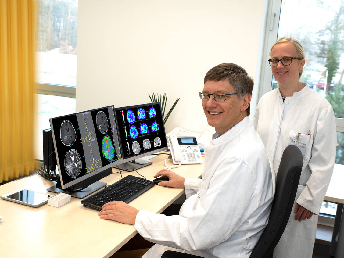 Professor Dr. Ulrich Herrlinger und Dr. Christina Schaub mit den Bildern eines Glioblastom-Patienten nach der Kombinationstherapie. / Foto: UKB/Katharina Wislsperger