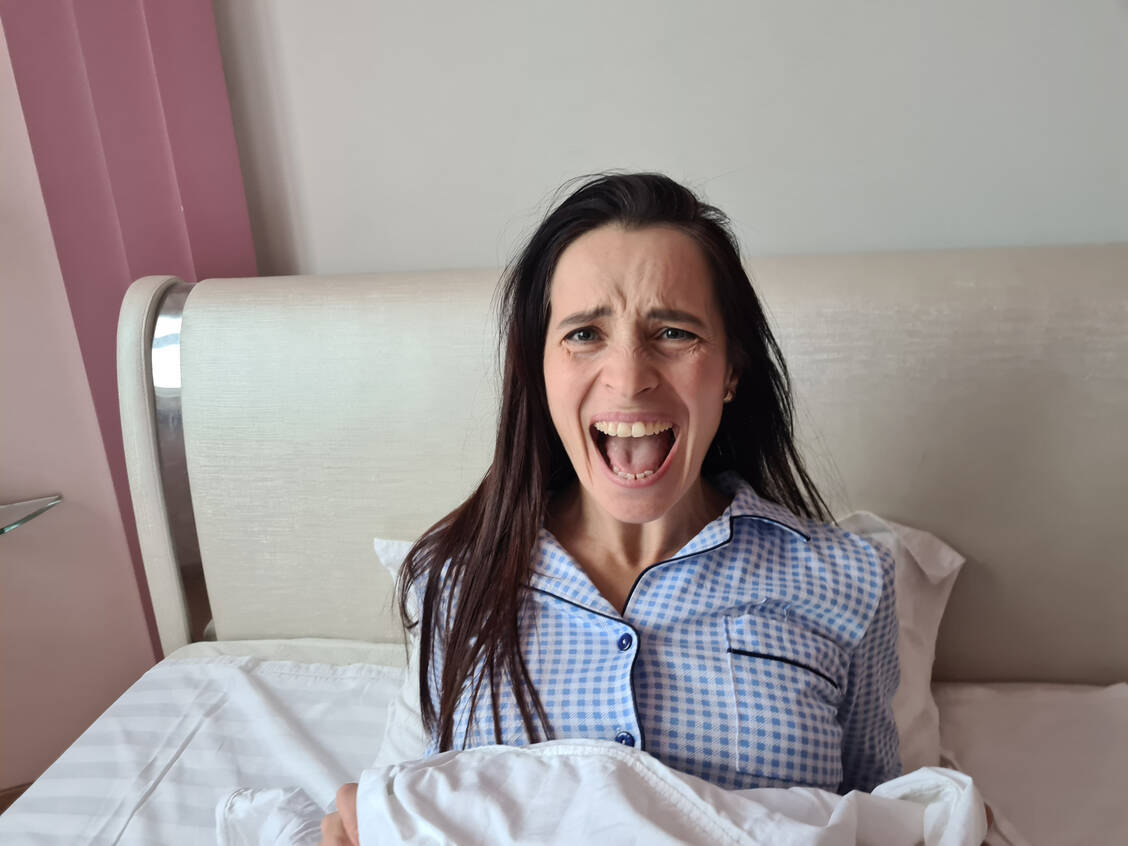Senkrecht im Bett: Wie man belastende Träume einordnet und was hilft, ihnen den Schrecken zu nehmen. / © Shutterstock/NMK-Studio