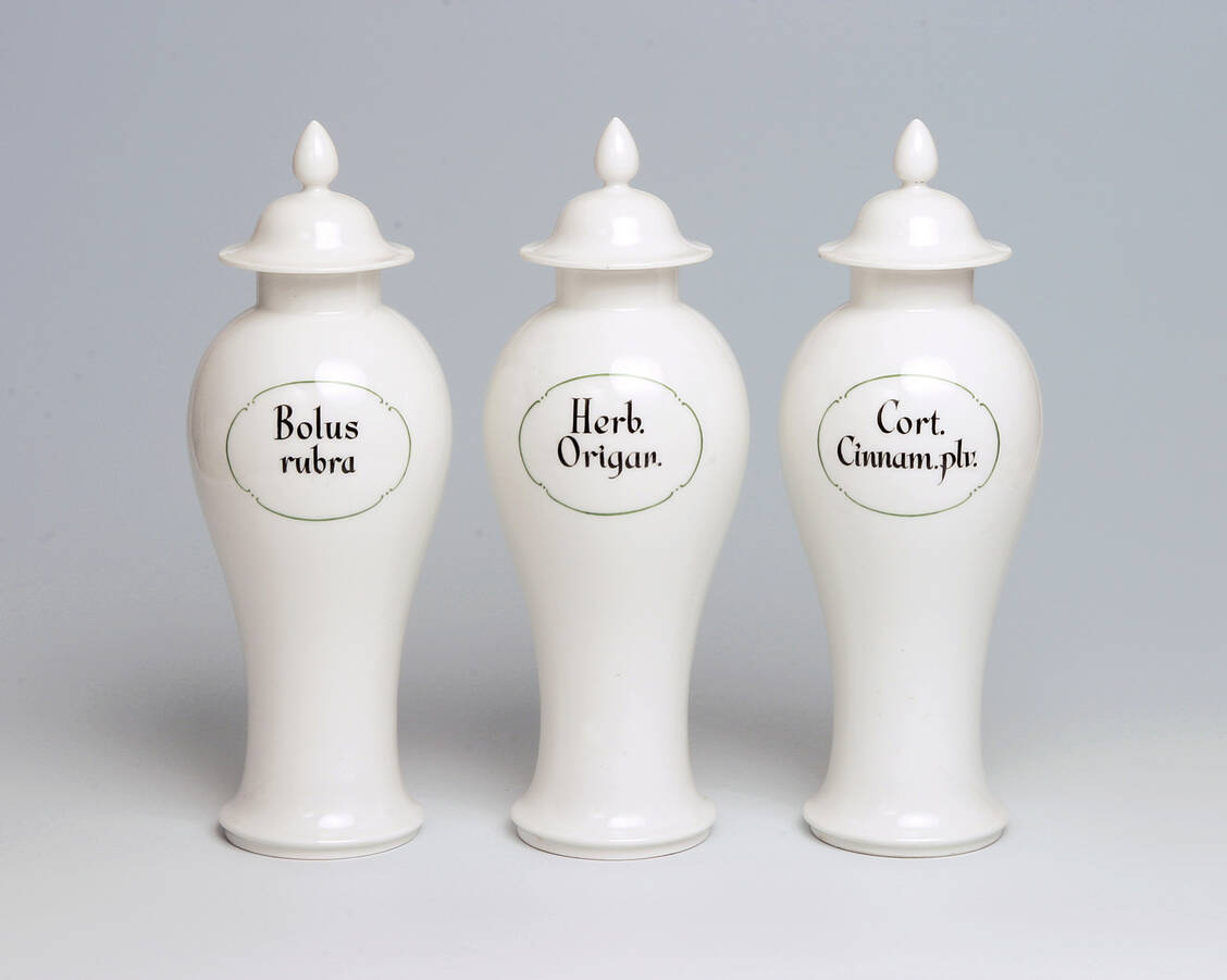 Abbildung 1: Drei Porzellan-Standgefäße aus der ehemaligen Internationalen Apotheke Berlin. Hersteller: KPM Berlin, circa 1930 (Maße: H 33,5 cm, Durchmesser Boden 9 cm), Inv.-Nr. II B 533, II B 528, II B 450 / Foto: Deutsches Apotheken-Museum