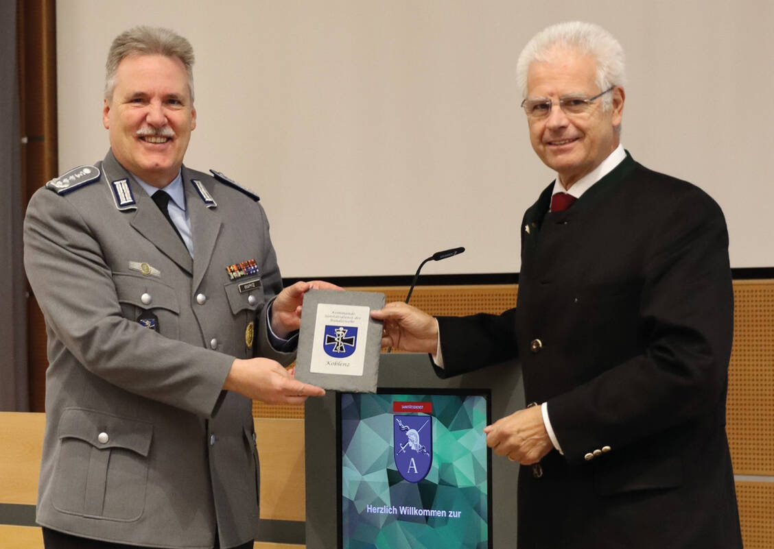Oberstapotheker Arne Krappitz (links) überreicht Thomas Benkert das Wappen des Kommandos Sanitätsdienst der Bundeswehr. / © Markus Stahl