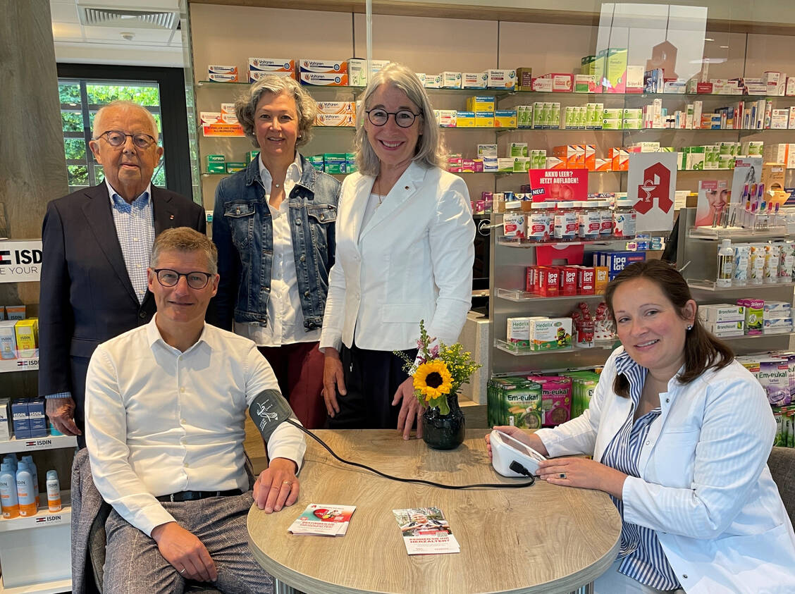 Apothekerin Juliane Hermes (rechts) bei der Blutdruckmessung von Münsters Oberbürgermeister Tilman Fuchs (sitzend). Mit dabei: Professor Dr. Gerd Assmann (Gründer und Vorstandsvorsitzender der Assmann-Stiftung für Prävention), Gabriele von Elsenau Overwiening (Präsidentin AKWL, rechts) und Dr. Claudia Brüning (Vorstandsmitglied AKWL und Kuratoriumsmitglied der Assmann-Stiftung für Prävention). / © AKWL/Sokolowski