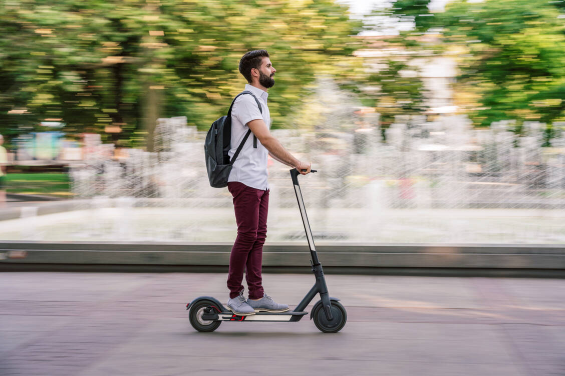 Gern schnell und ohne Helm unterwegs: E-Roller-Fahrer haben ein besonders hohes Risiko für schwere Kopfverletzungen. / © Getty Images/Petko Ninov