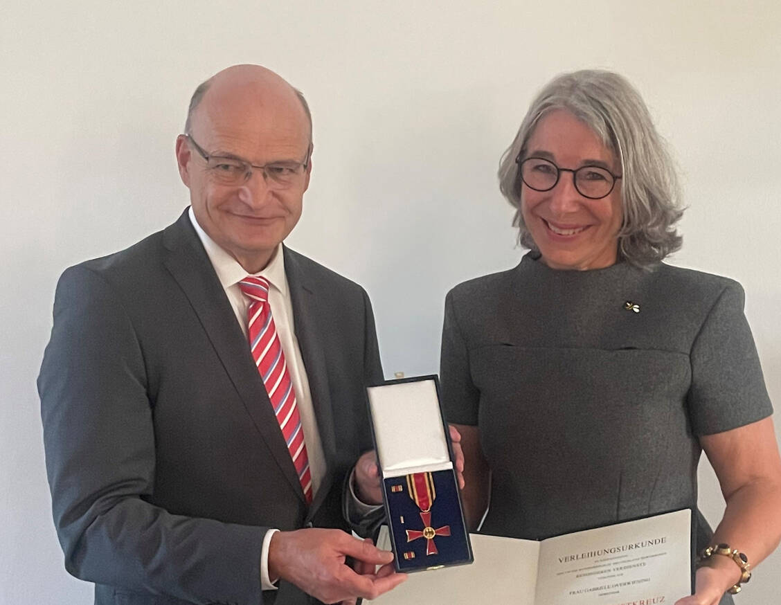 Martin Sommer, Landrat des Kreises Steinfurt, hat ABDA-Präsidentin Gabriele Regina Overwiening Orden und Verleihungsurkunde überreicht. / © AKWL