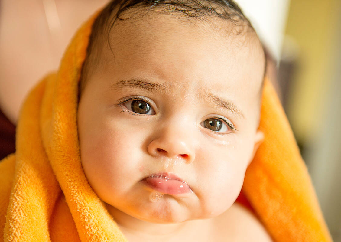 Bis zum 18. Lebensmonat können Babys den Speichelfluss noch nicht richtig kontrollieren. Dieser fließt oft nach außen ab. / Foto: Adobe Stock/phokrates