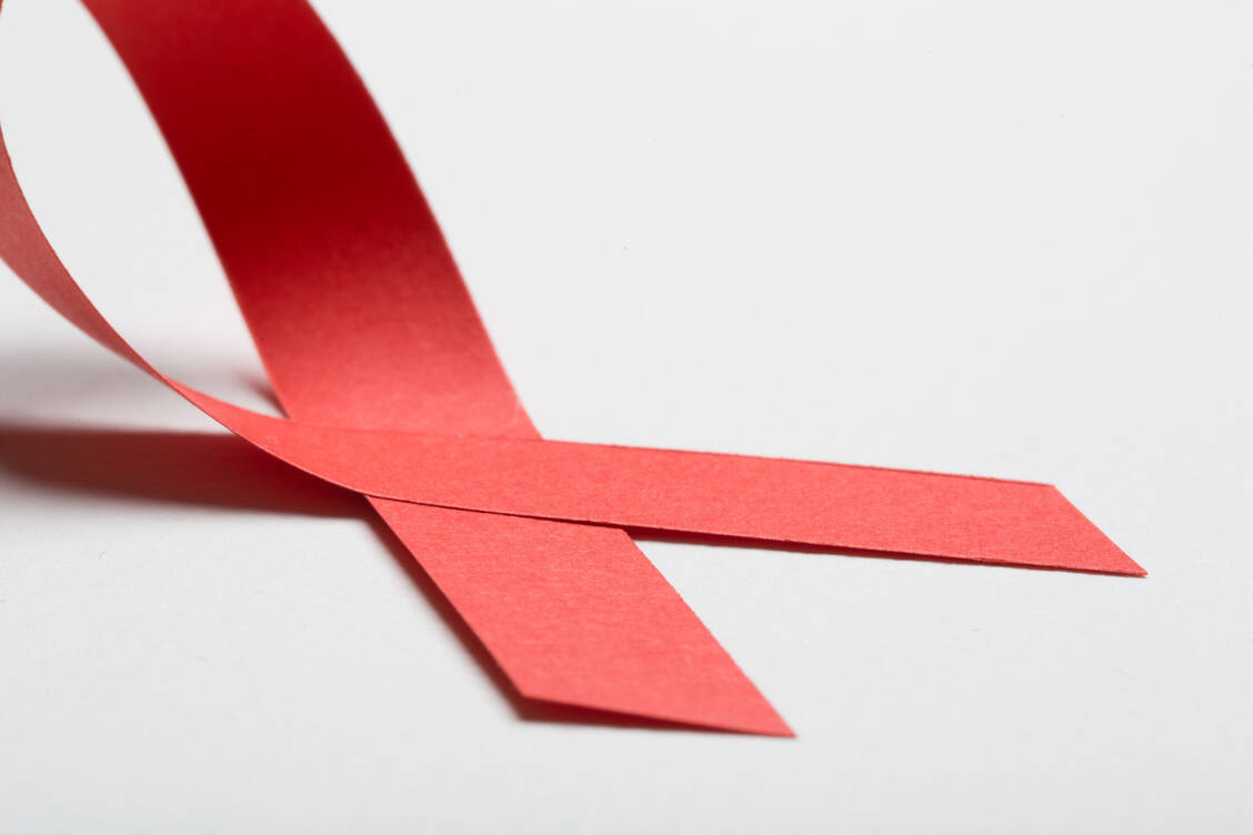 Die rote Schleife symbolisiert Solidarität mit HIV-positiven oder aidskranken Menschen. / Foto: Getty Images/Boris Zhitkov