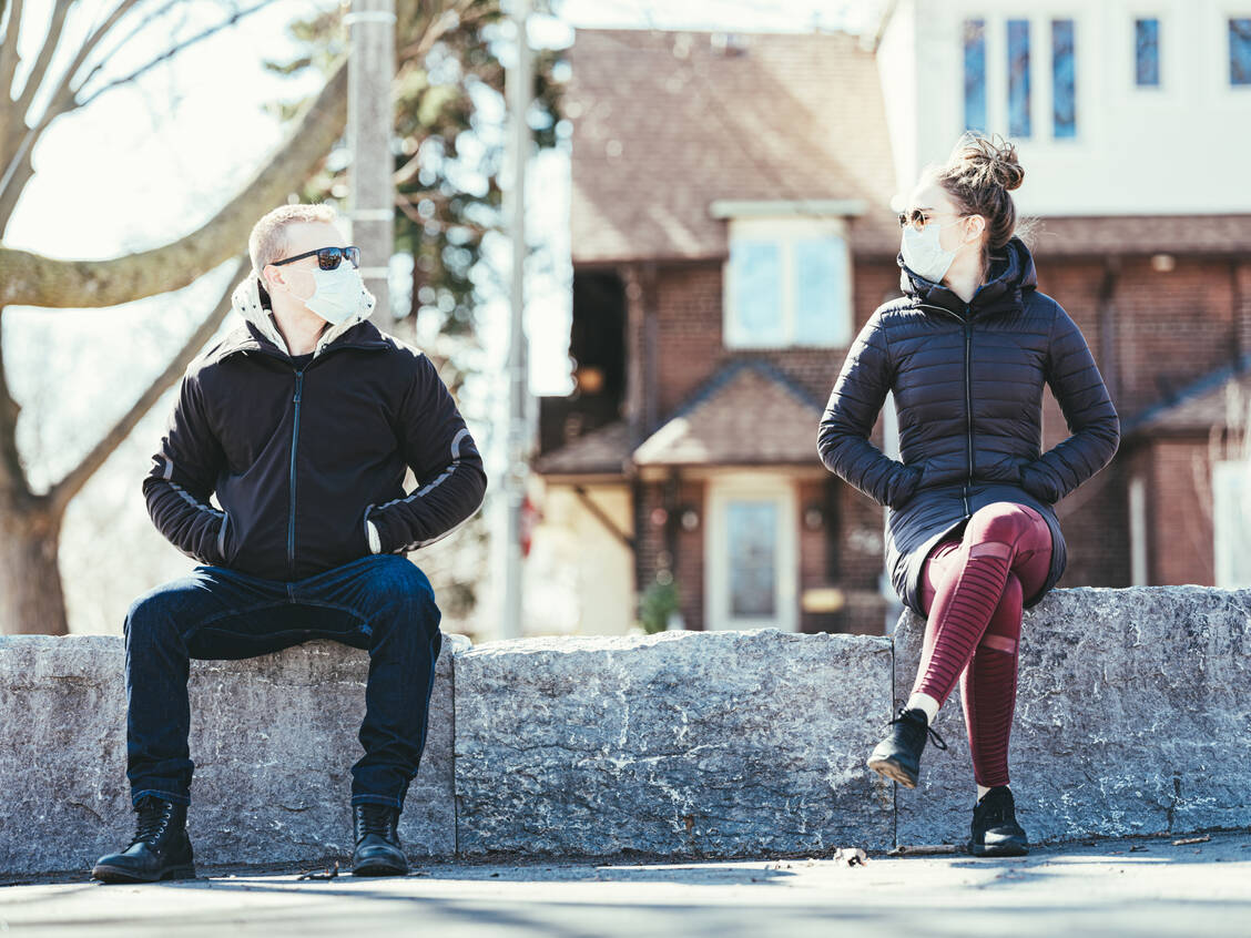 Masken halten Tröpfchen zurück, erinnern den Träger aber auch an die Abstandsregeln. Beides zusammen trägt möglicherweise dazu bei, dass sie die Ausbreitung von SARS-CoV-2 verlangsamen können. / Foto: Getty Images/Sisoje